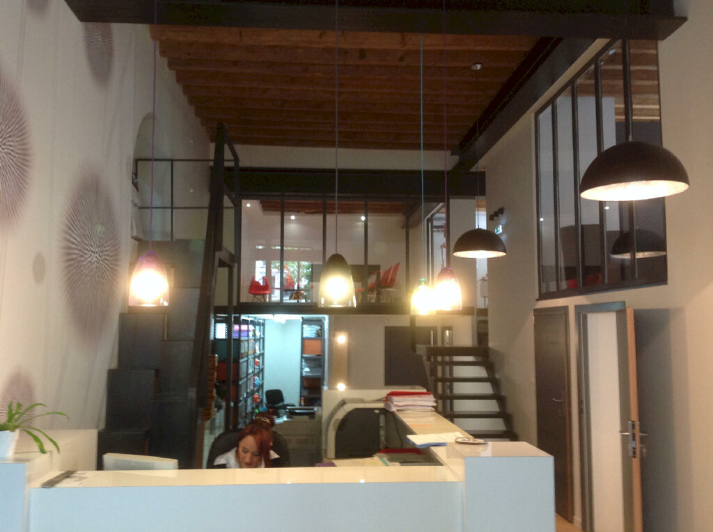 Comptoir d’accueil et open space du cabinet d’avocats à lyon, mis en lumière par suspensions et spots led