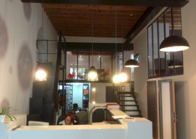 Comptoir d’accueil et open space du cabinet d’avocats à lyon, mis en lumière par suspensions et spots led