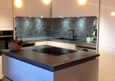 Cuisine design avec îlot central, spots encastrés et suspensions au-dessus du plan de cuisson, rénovation électrique complète