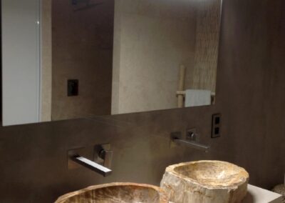 Double vasque en pierre sous miroir lumineux, appareillages muraux haut de gamme pour une salle de bain de standing