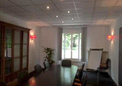 Salle de réunion du cabinet d’avocats, éclairée par spots encastrés et appliques murales, câblage courant fort et faible entièrement repris
