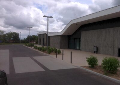 Vue d’ensemble de l’espace capella et de son parvis, avec parking et candélabres extérieurs alimentés par la nouvelle installation électrique