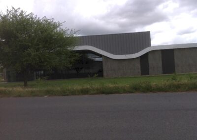 Vue latérale vitrée de l’espace capella, grande baie et toiture courbe, illustrant la salle des fêtes moderne et fonctionnelle après rénovation